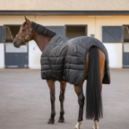 Virolla 100g Black stable rug rear view - premium quilted black fabric on hindquarters of bay thoroughbred, stable yard
